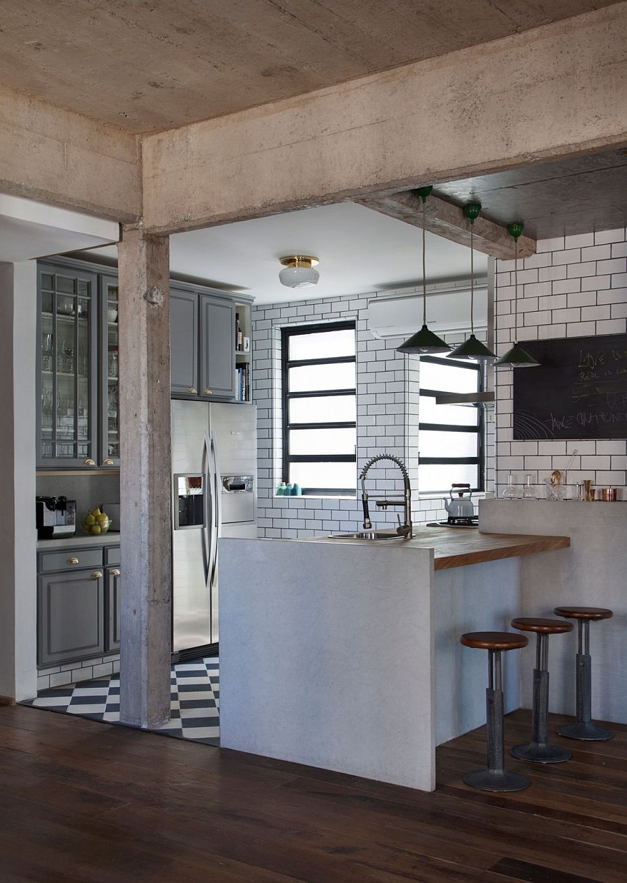 Gray cabinets and tiles separate the kitchen from the small living space