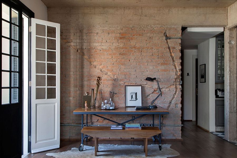 Home workspace with table on wheels and exposed brick wall