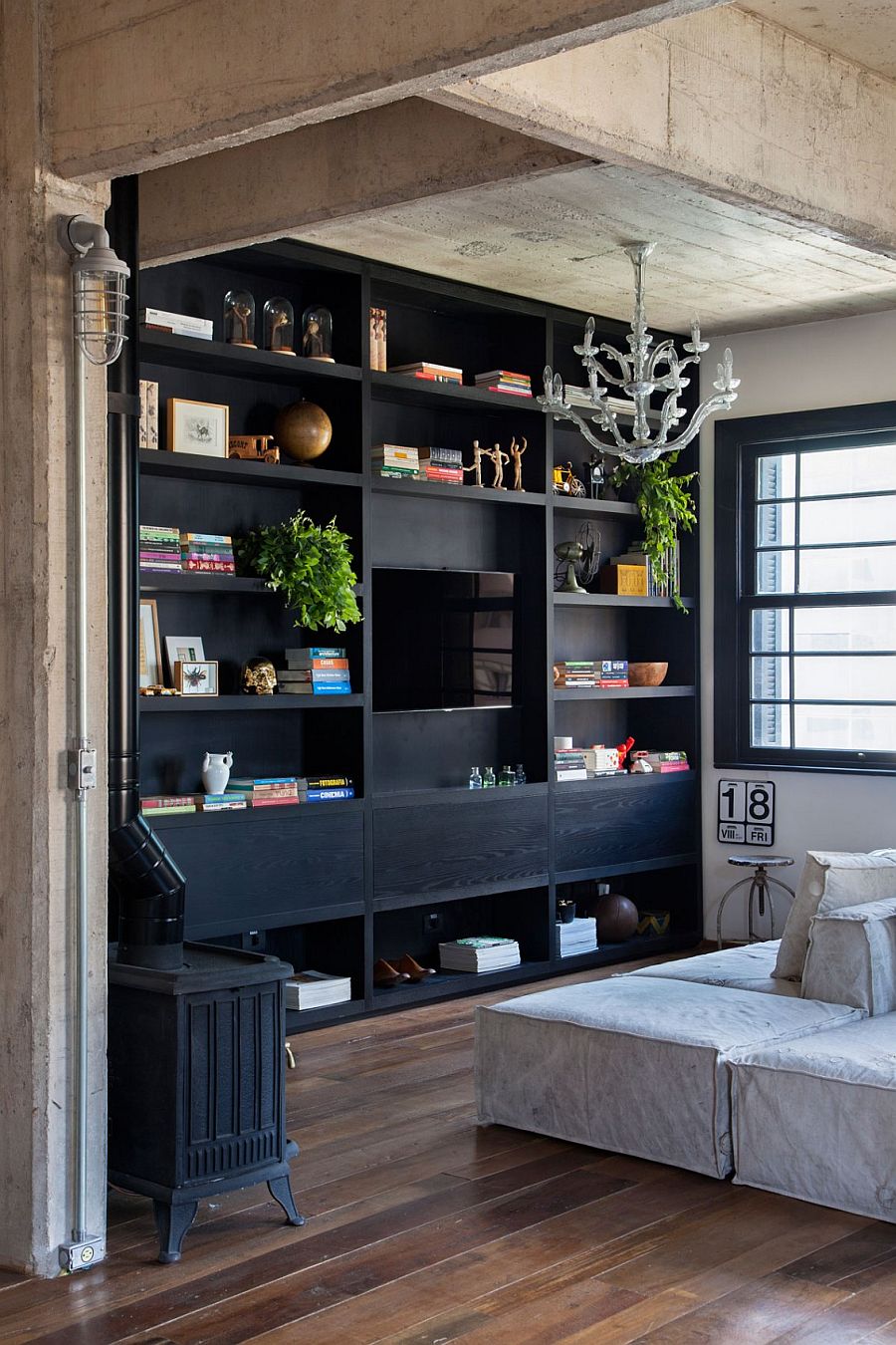 Large, open bookshelf in dark wood anchors the light-filled living room