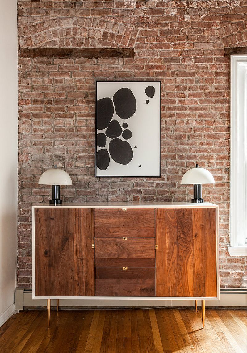 Lovely modern wooden buffet in the living and dining space with brick walls