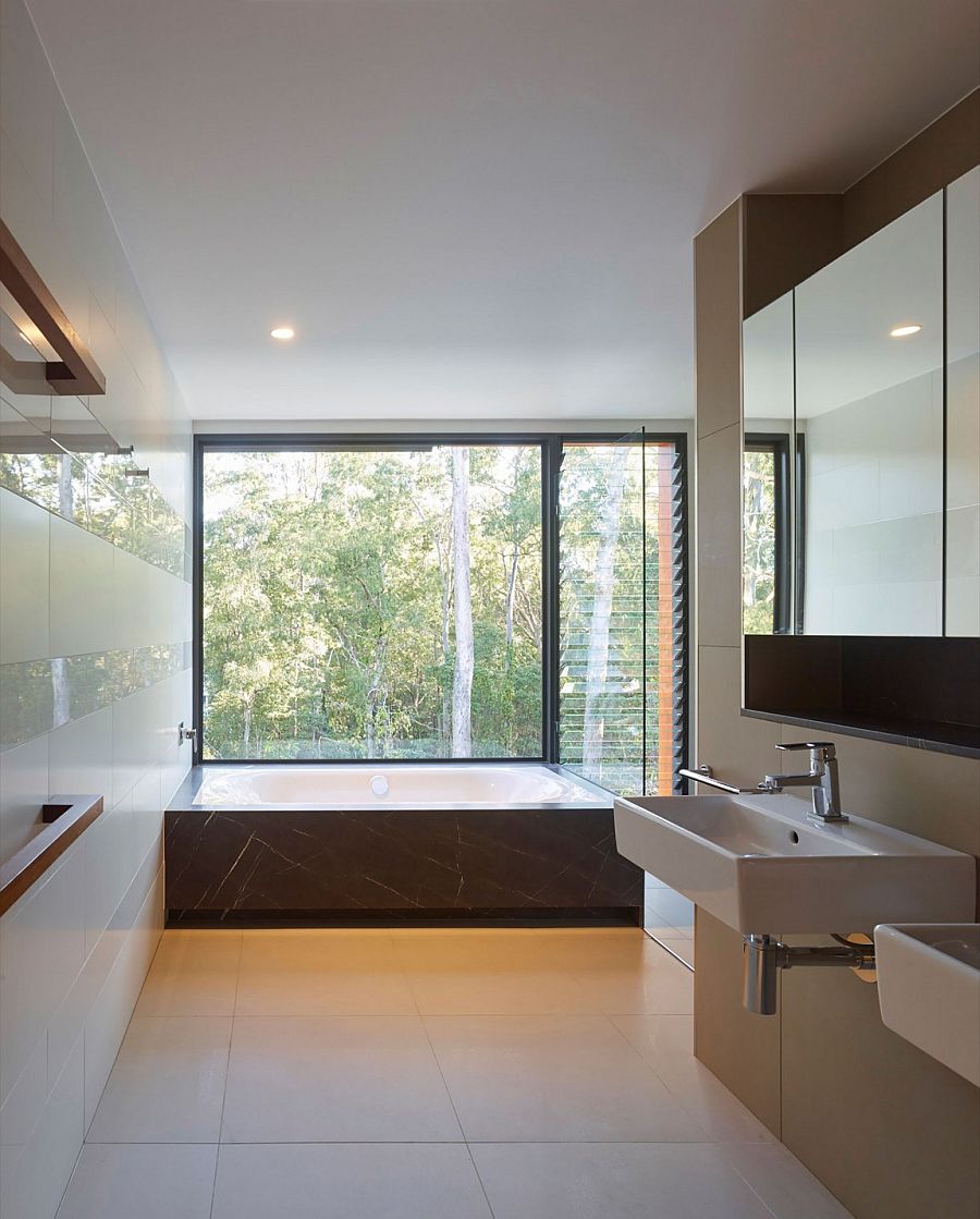 Luxurious contemporary master bath with lovely view of the landscape around it