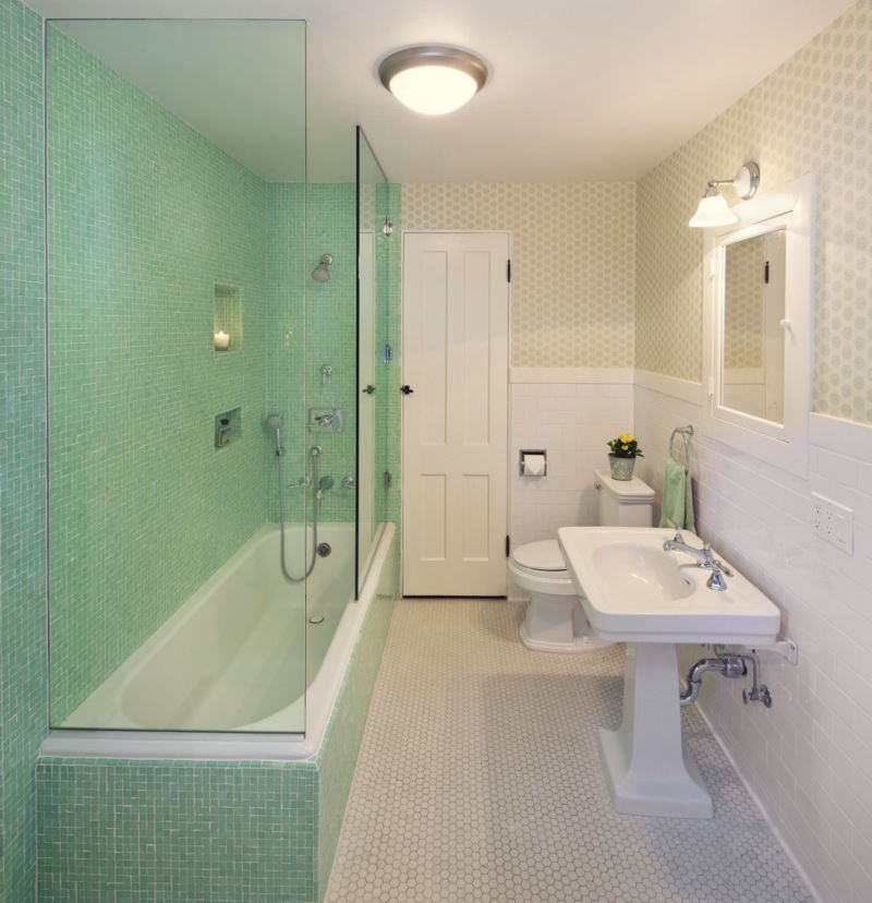Mint tile shower in a wallpapered bathroom