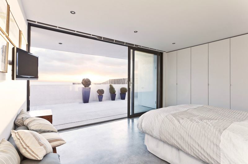 Modern bedroom with a balcony view of plants