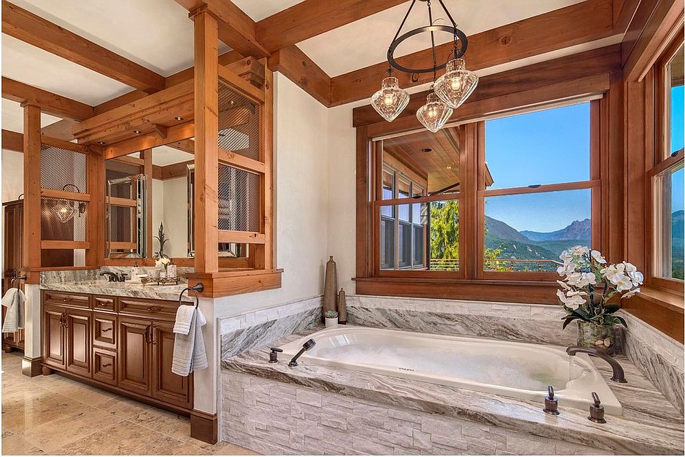 Rustic bathroom with stone bathtub and lovely mountain views [Design: Fine Design Interiors]