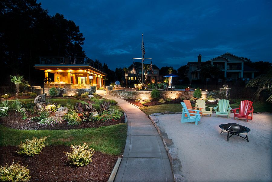 Sandy sitting zone with colorful chairs and a fire pit next to the lake