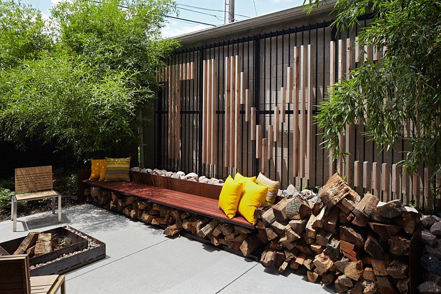 Small backyard with concrete deck and stacked firewood