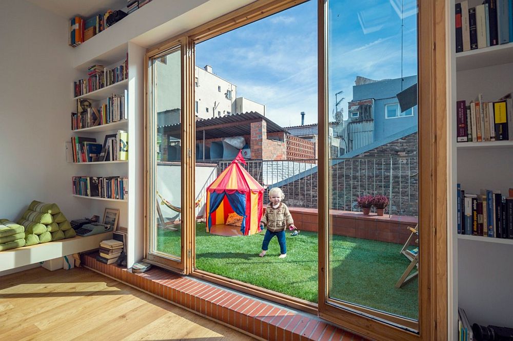 Small gardened terrace and kids' play area connected with home studio