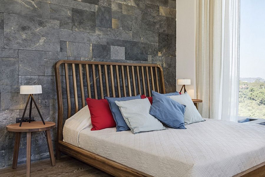 Stone accent wall and woodsy bed for the Mediterranean bedroom