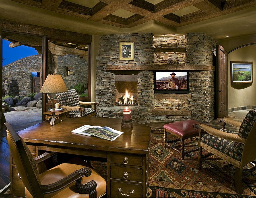 Stone wall with fireplace and TV becomes the showstopper in this home office [Design: Bess Jones Interiors]