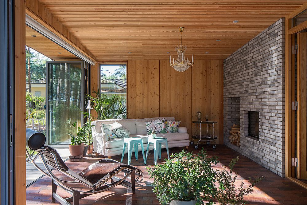 Stylish sunroom with folding glass doors and stone and wood walls