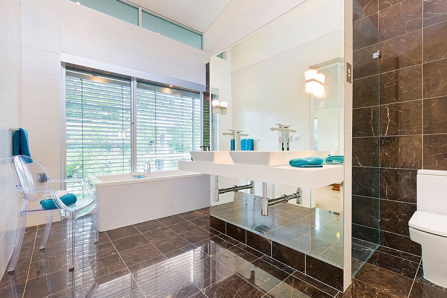Super sleek contemporary bathroom with a white bathtub abd acrylic chair