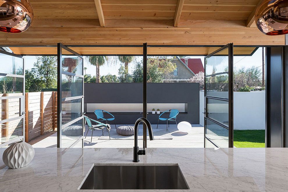 View of the revamped backyard and deck from the spacious glass and metal extension