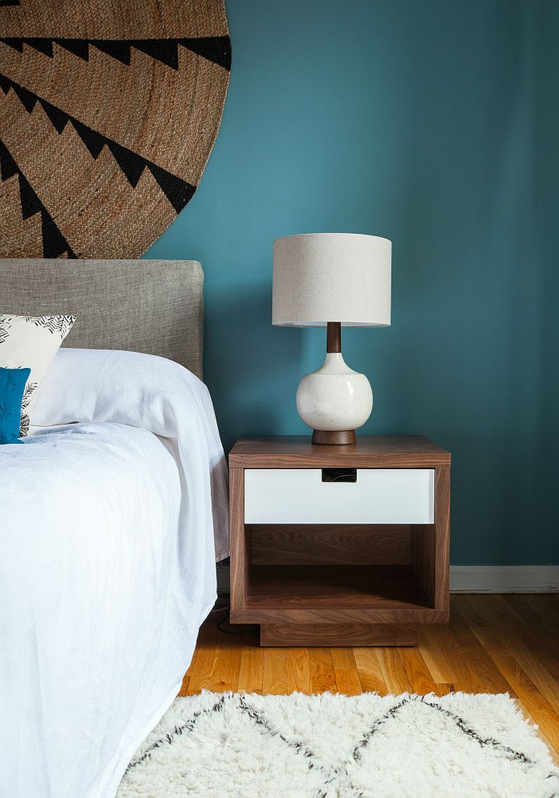 Walnut bedside table and table lamp give the contemporary bedroom a midcentury vibe