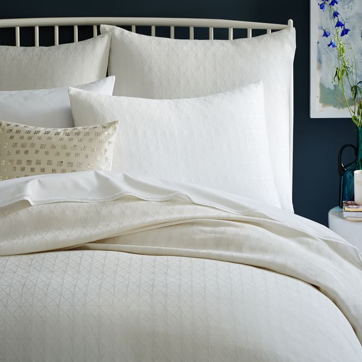 White bedding is a refreshing choice with dark walls