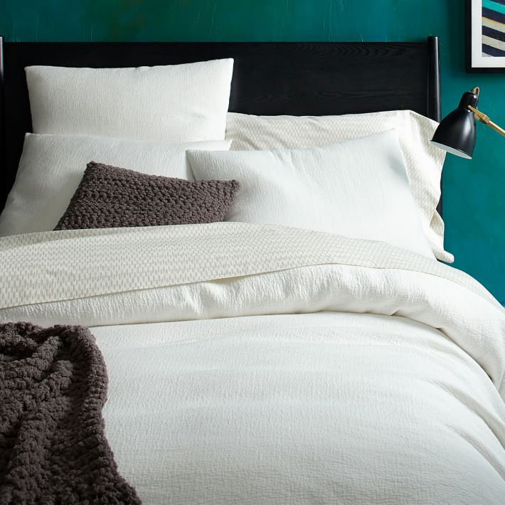 White bedding pops against a teal wall