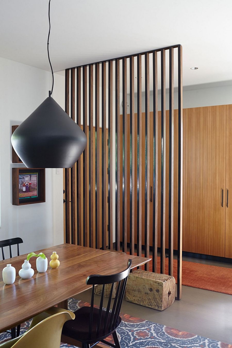 Wooden slats delineate the dining space from the living room