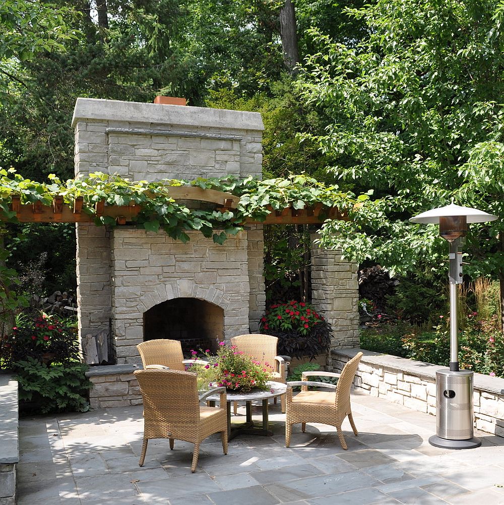 A simple pergola structure covered in vine offers ample shade for the outdoor living area