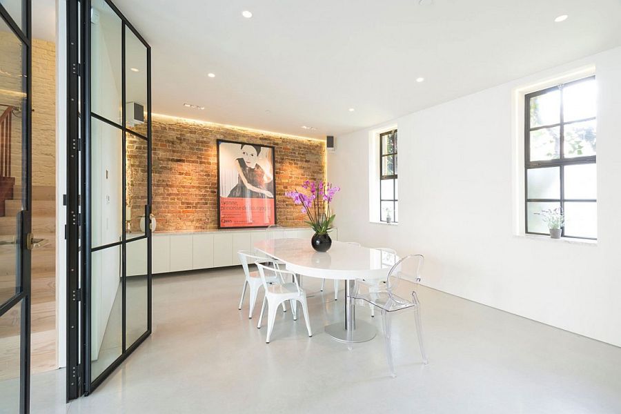 Beautiful dining room in white with an exposed brick wall as accent feature