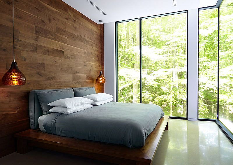 Bedroom with wooden accent wall and bedside pendant lighting