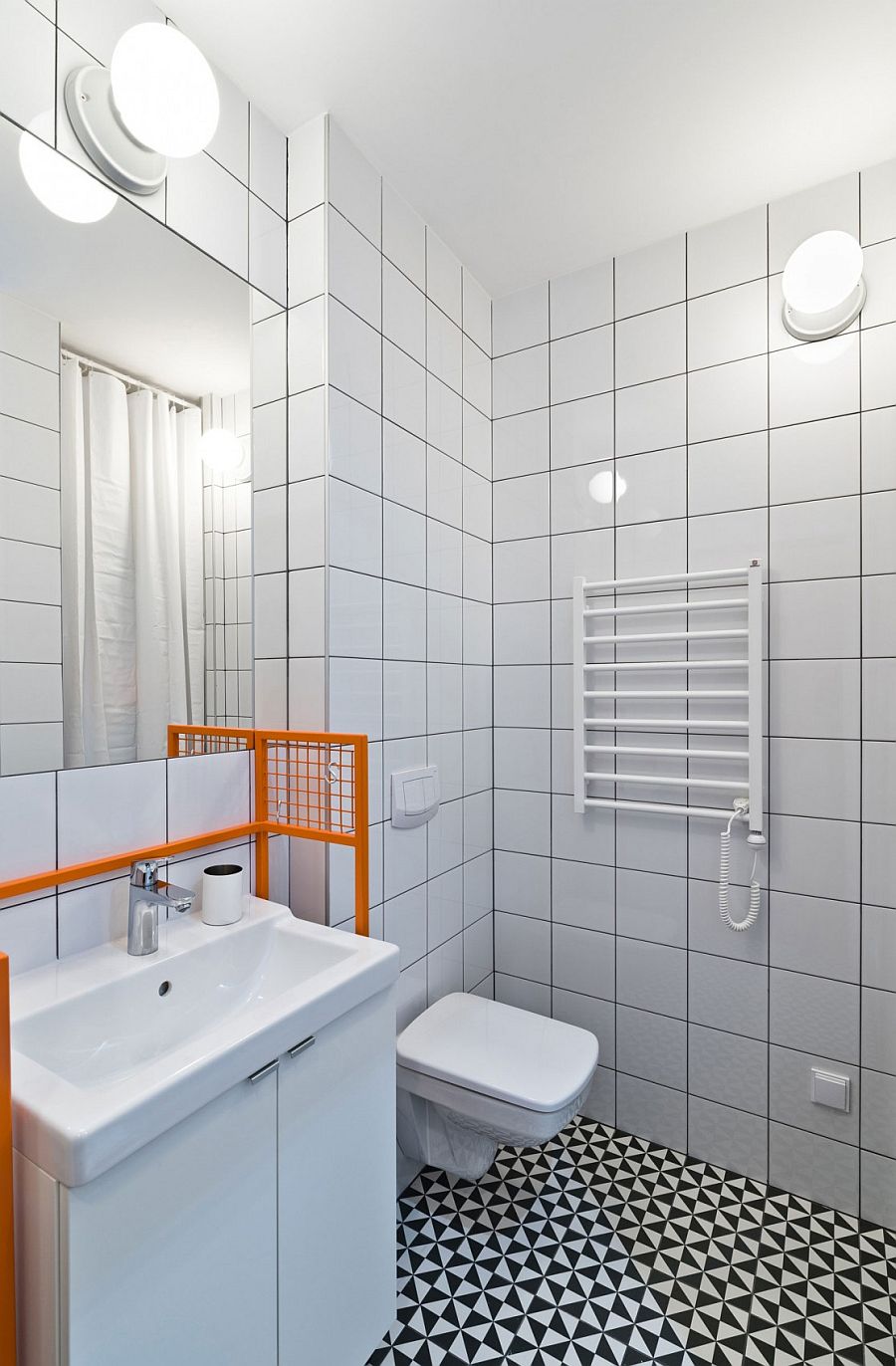 Black, white and gray shape a stylish, small bathroom inside the Poznan apartment