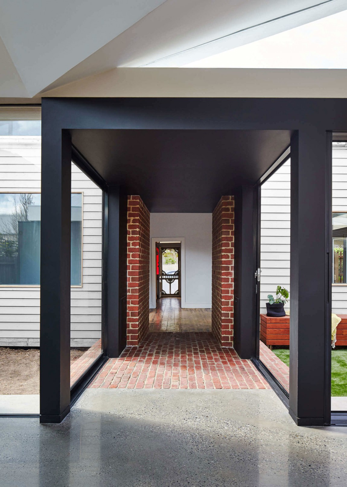 Brick and glass tunnel connects the old and new structures at this revamped Aussie Residence