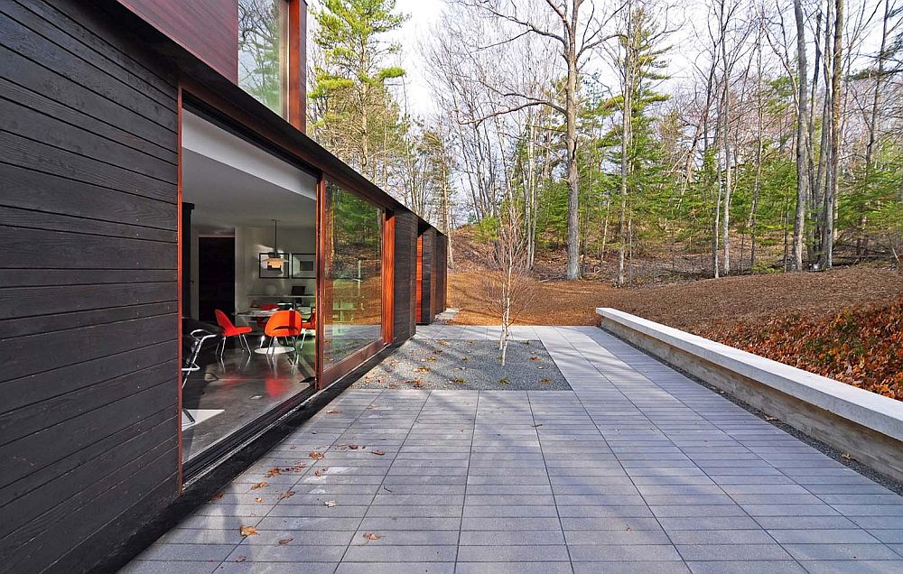 Concrete patio around the beautiful forest house with sliding glass doors