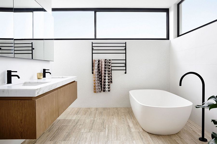 Contemporary bathroom with penny tiles on the wall, freestanding bathtub and floating wooden vanity