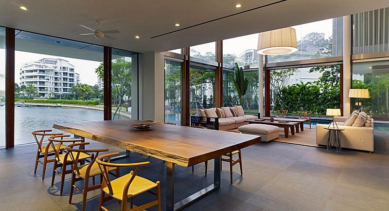 Contemporary dining room of Sentosa Cove home with a view of the canal and live edge dining table