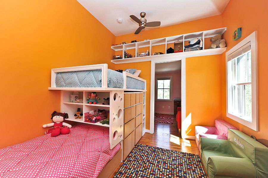 Contemporary kids’ bedroom in orange offers ample storage space [Design: Arlington Construction Management]