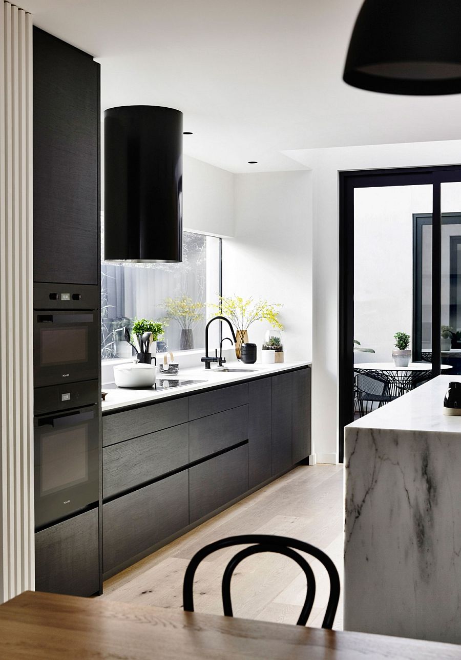 Dark cabinets add contrast to the white kitchen with a gorgeou marble island