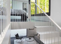 Delicate-and-sculptural-staircase-leads-to-the-master-bedroom-on-the-top-level-overlooking-the-forest-217x155