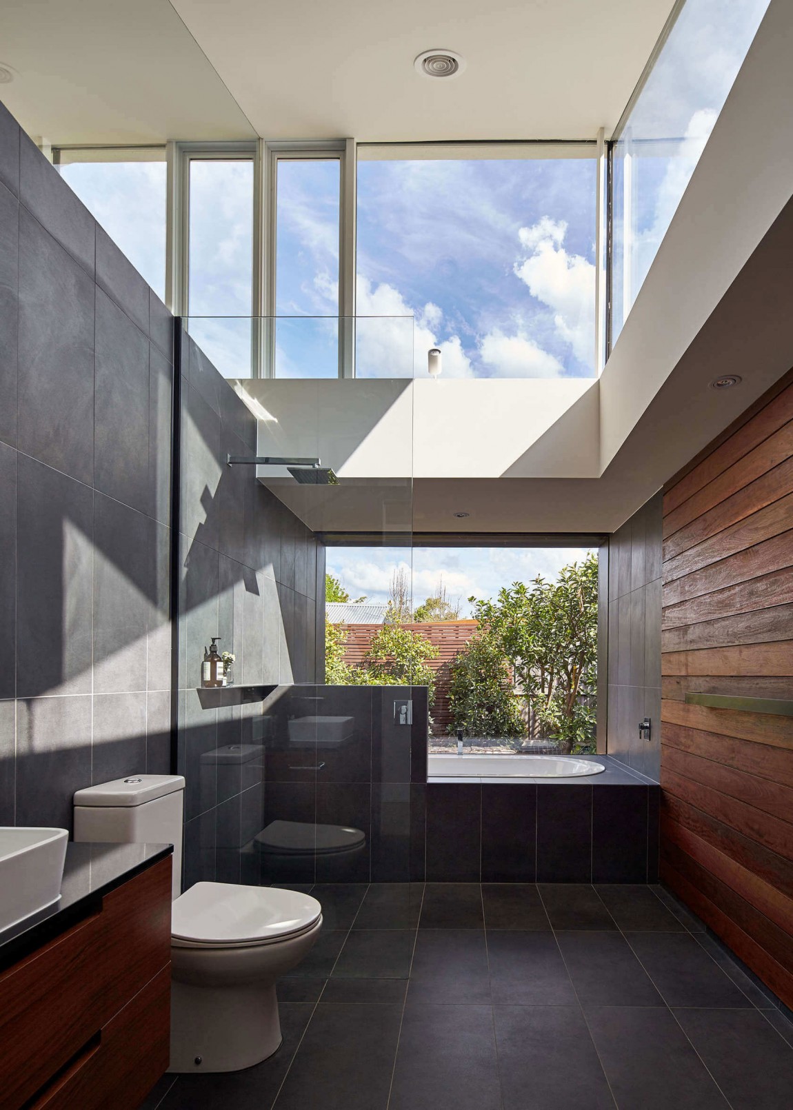 Ingenious bathroom design with accent wood wall and glassy charm