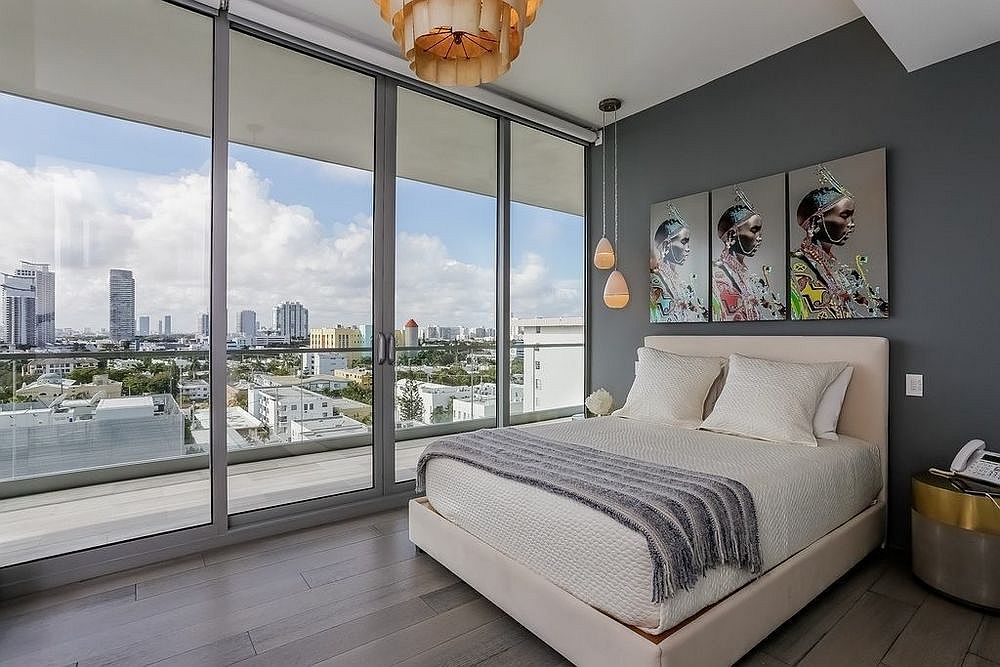 Interesting use of wall art in bedroom draped in gray