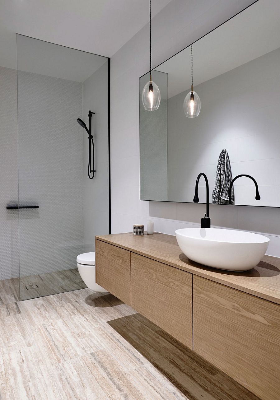 Lighting inside the white contemporary bathroom is kept minimal