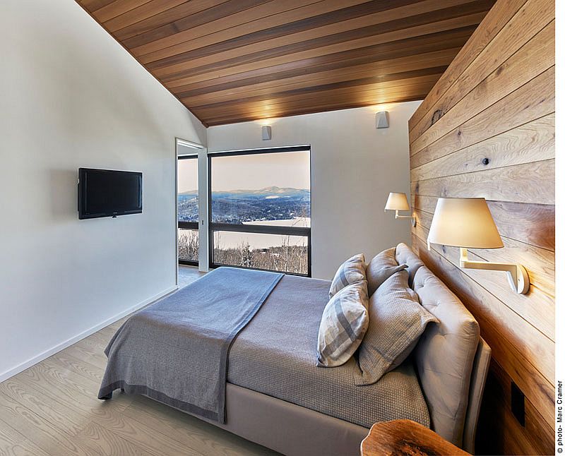 Master bedroom with an accent wooden wall and ceiling