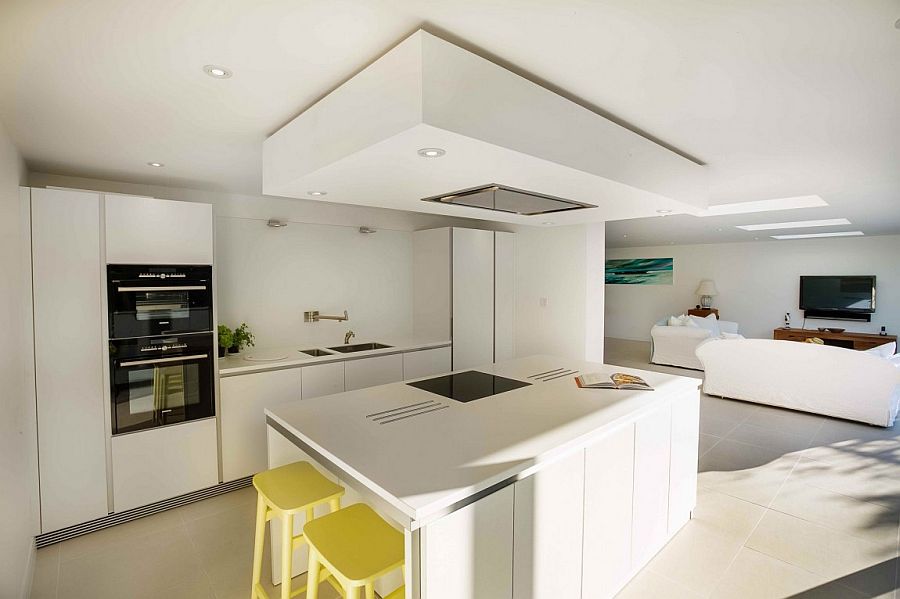 Open design of the new lower level brings sunlight into the contemporary kitchen in white