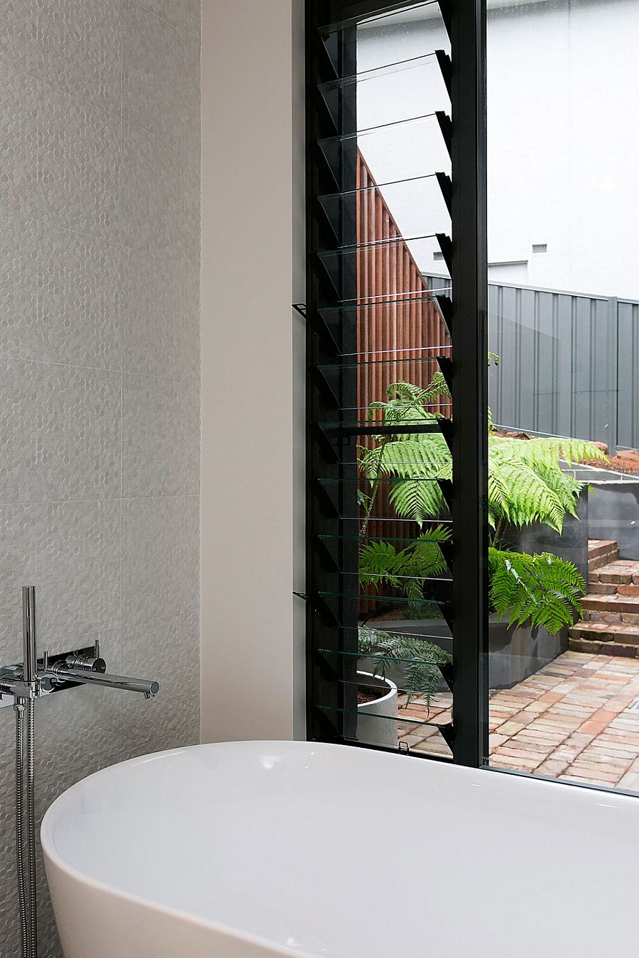 Penny tiles accent wall in the modern bathroom