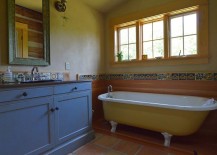 Rustic-bathroom-with-clawfoot-bathtub-in-yellow-and-vanity-in-blue-217x155