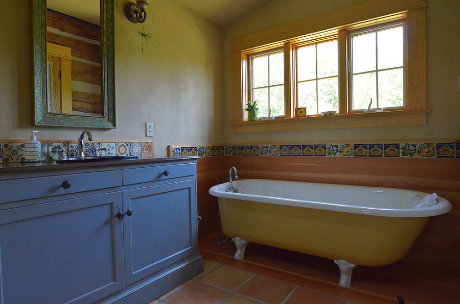 Rustic bathroom with clawfoot bathtub in yellow and vanity in blue [From: Sarah Greenman]