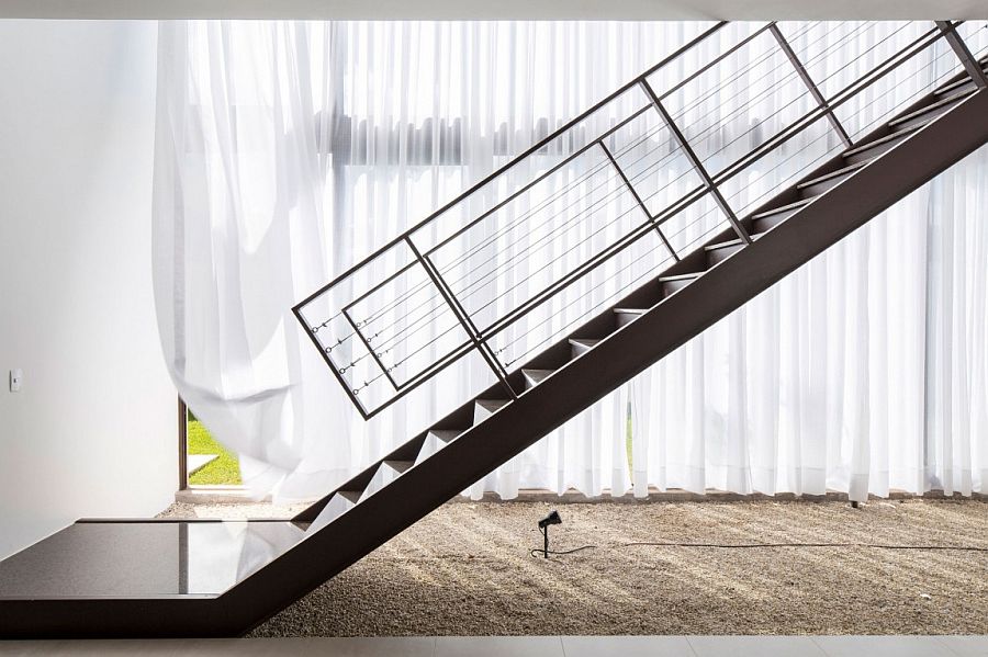 Sculptural steel staircase inside  contemporary Brazilian home