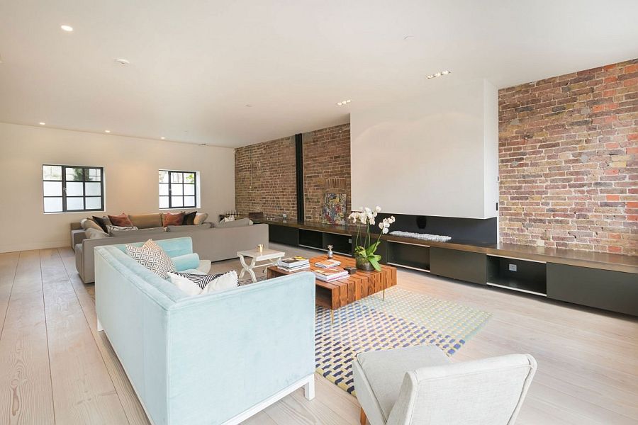 Sleek, modern cabinets and contemporary fireplace combined with exposed brick wall