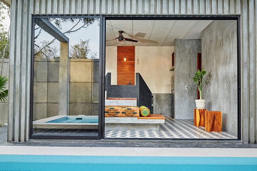 Sliding glass doors connect the indoor social zone with the pool