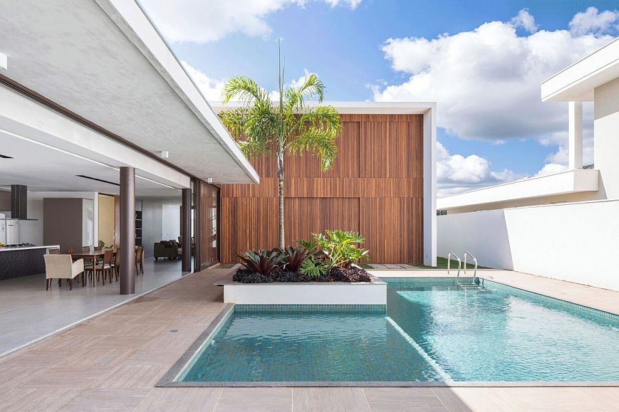 Sliding glass doors connect the lower level living area with the pool space