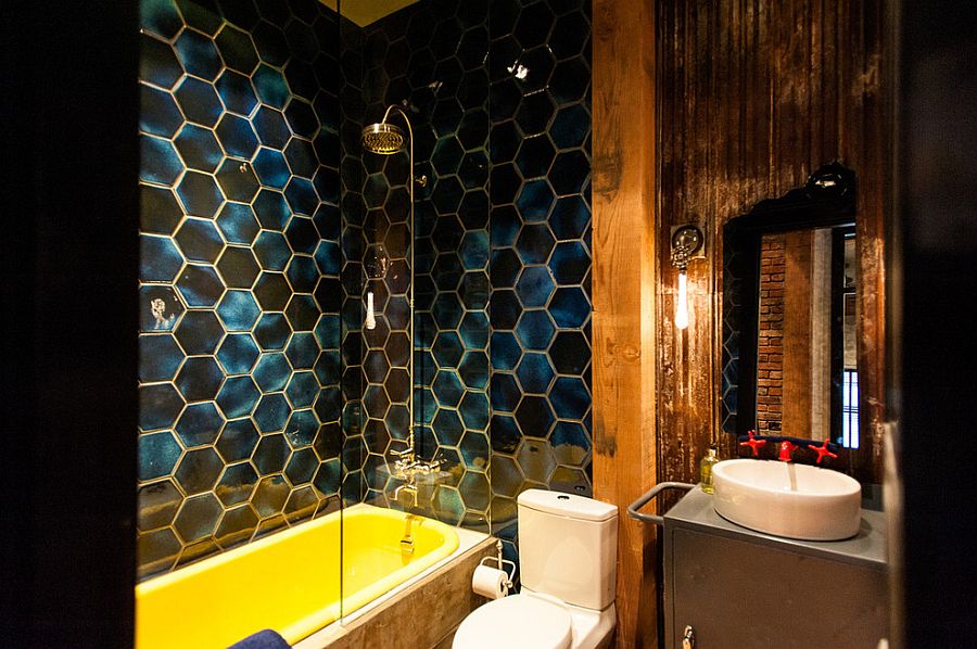 Stunning eclectic industrial bathroom with bold hexagonal tiles and a bathtub in yellow [Design: Beyond Beige Interior Design]