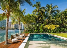 Wooden-deck-with-glass-railing-and-refreshing-backyard-landscape-of-the-Miami-home-217x155