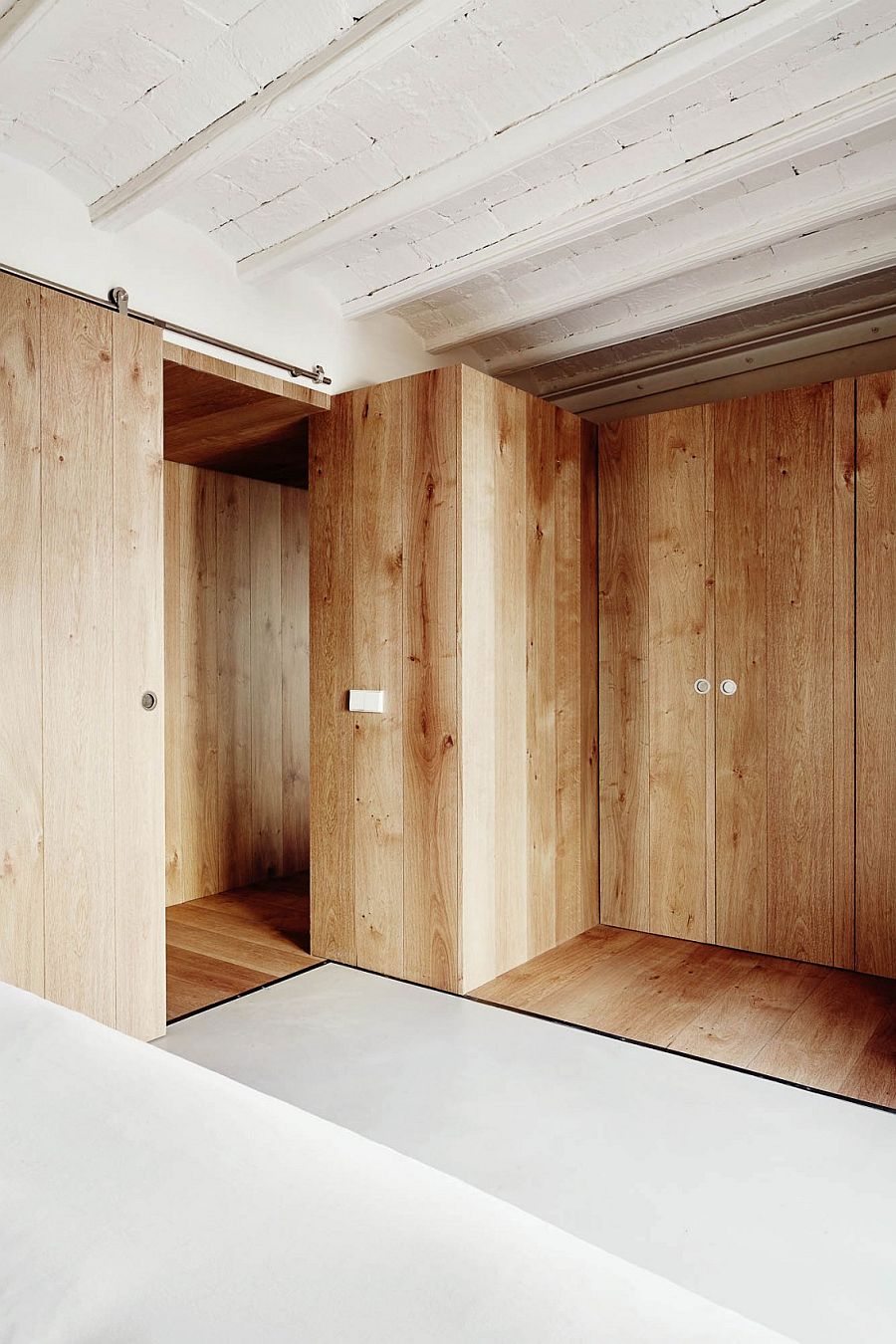 Wooden walls create smart partitions and private zones inside the tiny tourist apartment