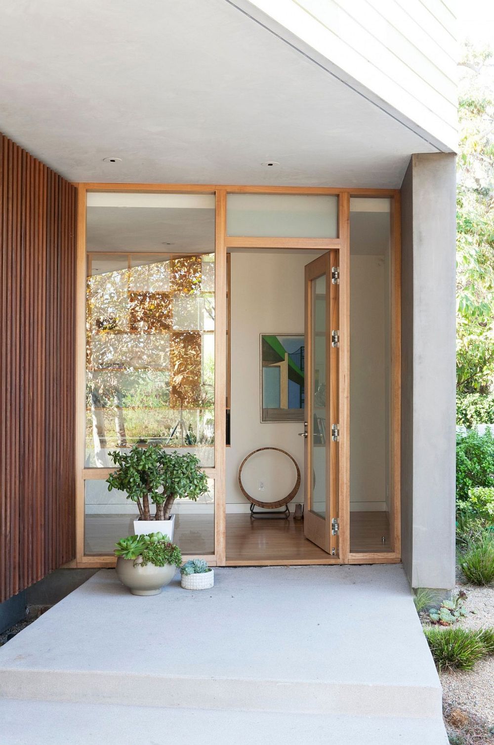 Entryway to the relaxing modern home in Santa Monica, California with wooden slats and potted plants