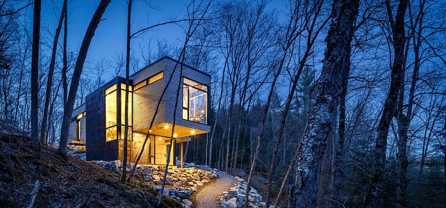Light adds inviting warmth and sparkle to the cottage in woods