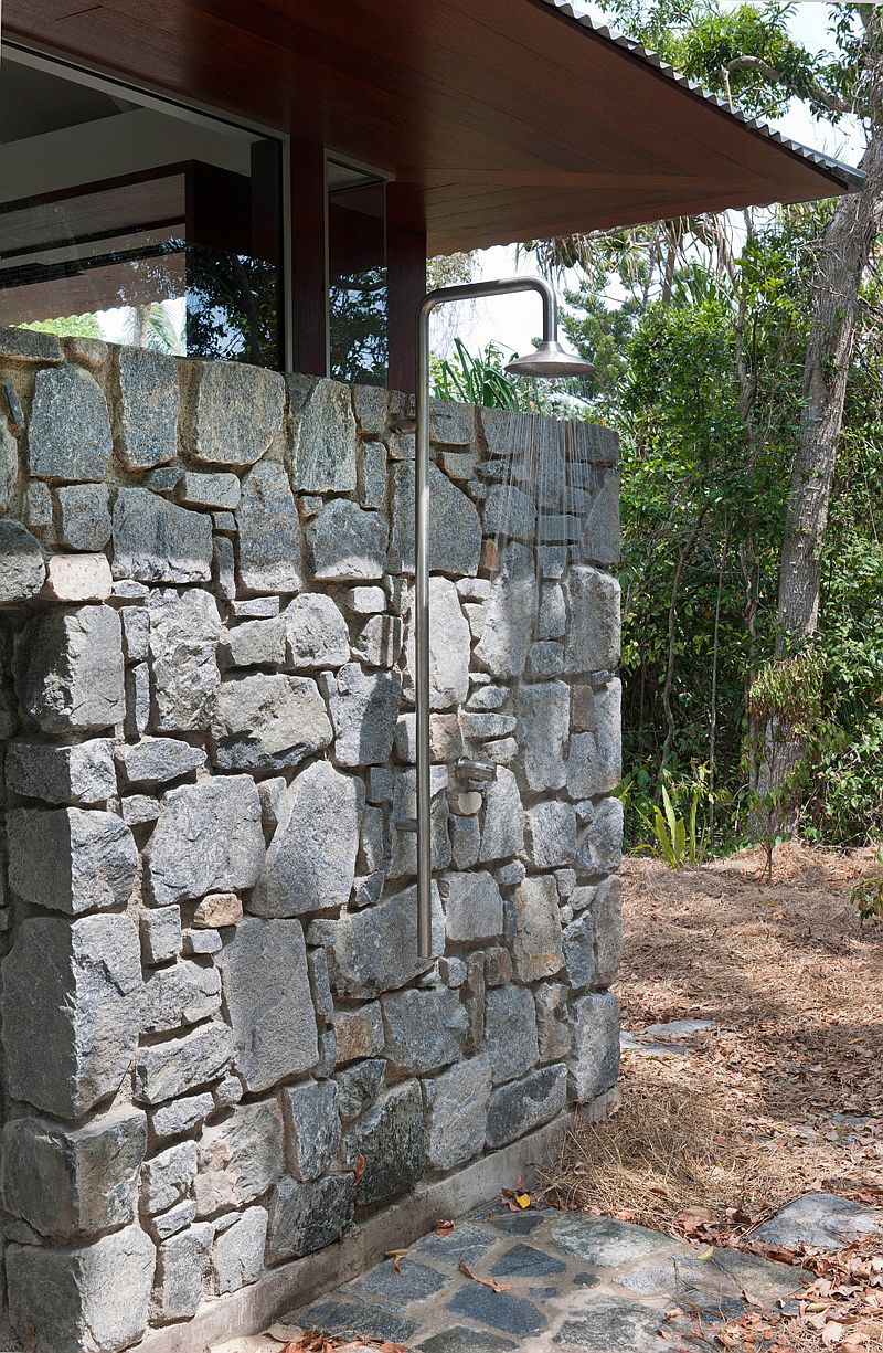 Outdoor shower area with stone wall