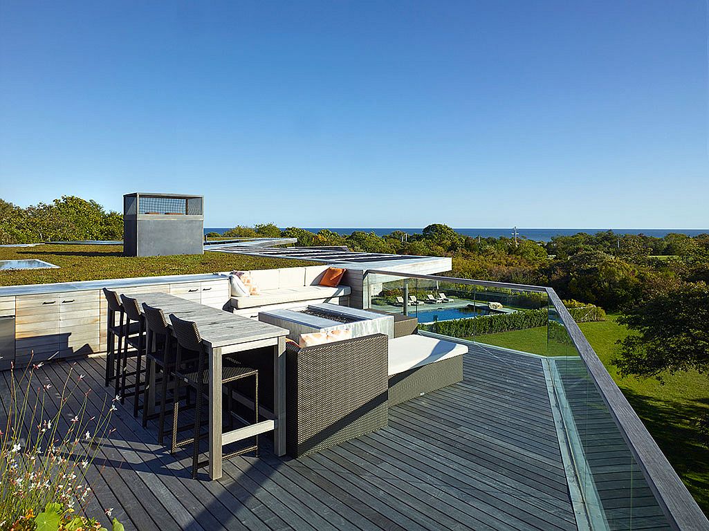 A small and cozy roof deck with dining space and ocean views